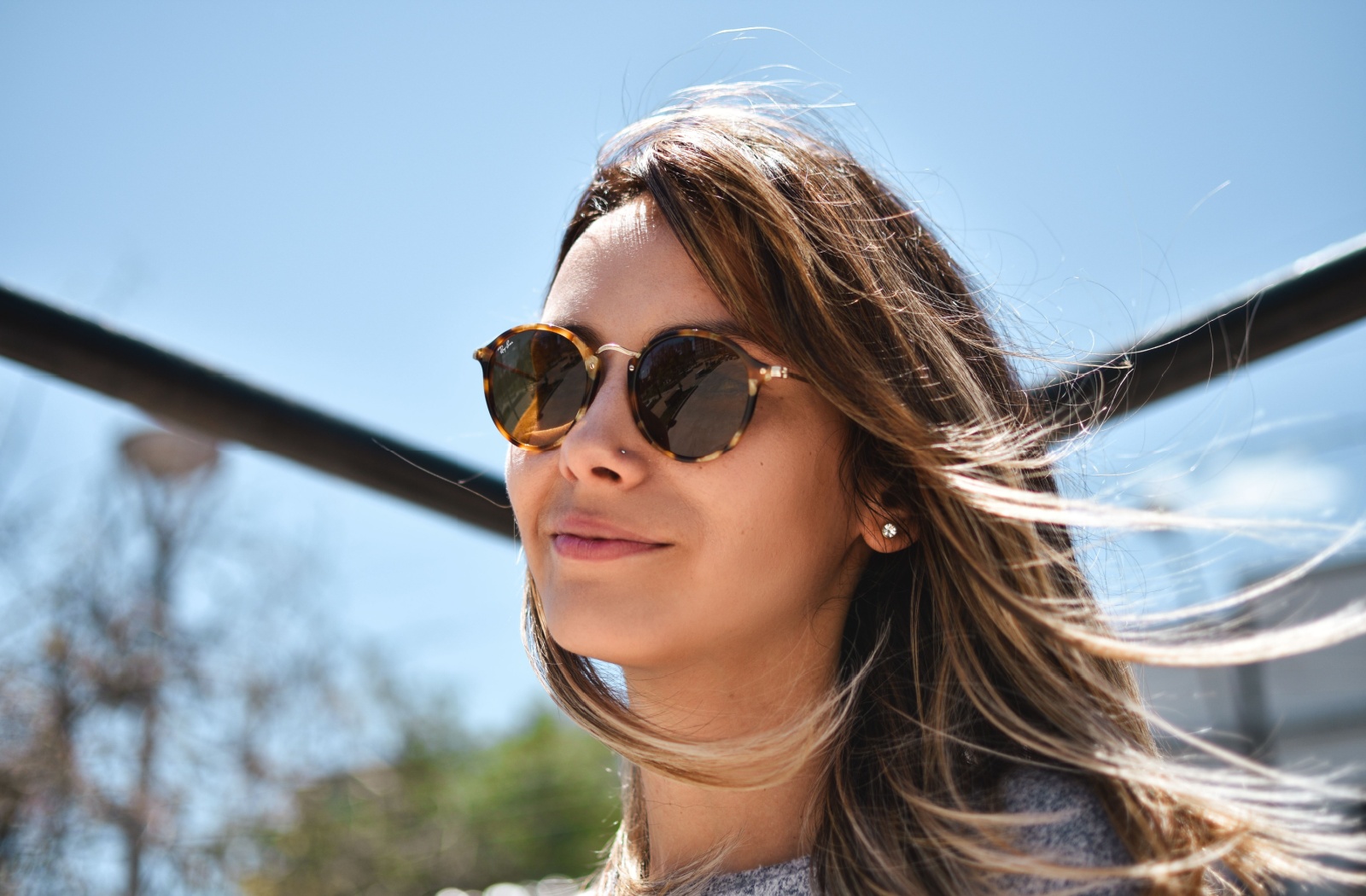 Woman smiling while wearing contact lenses and prescription sunglasses.