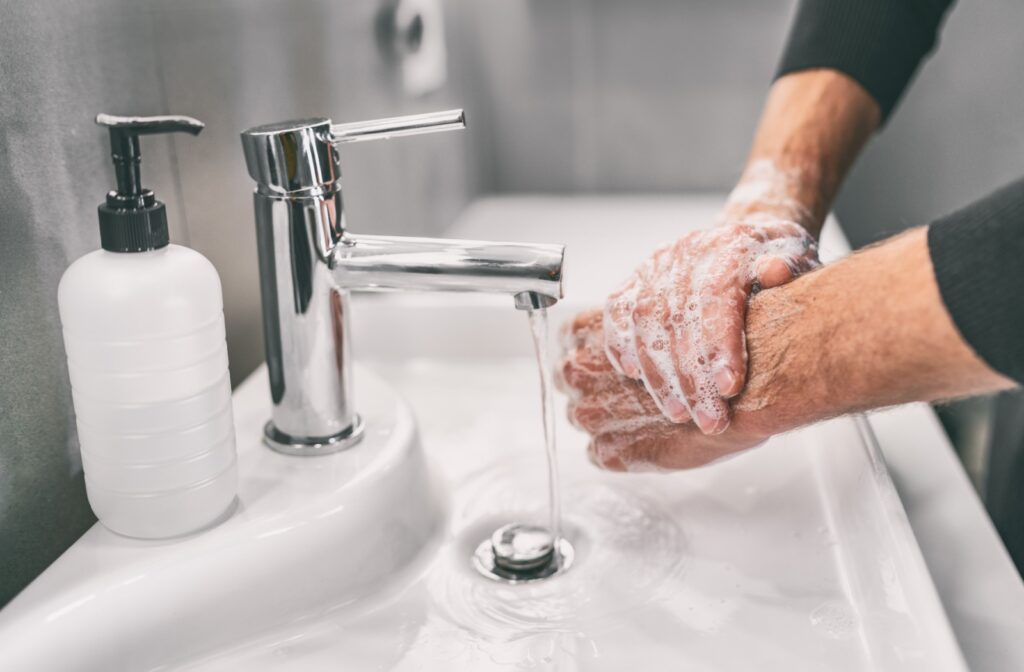 Handwashing with soap in a bathroom sink with a soap pump.