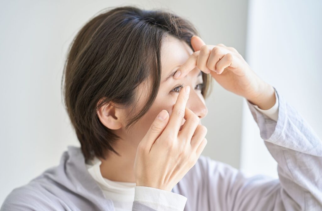 A person putting a contact lens into their eye