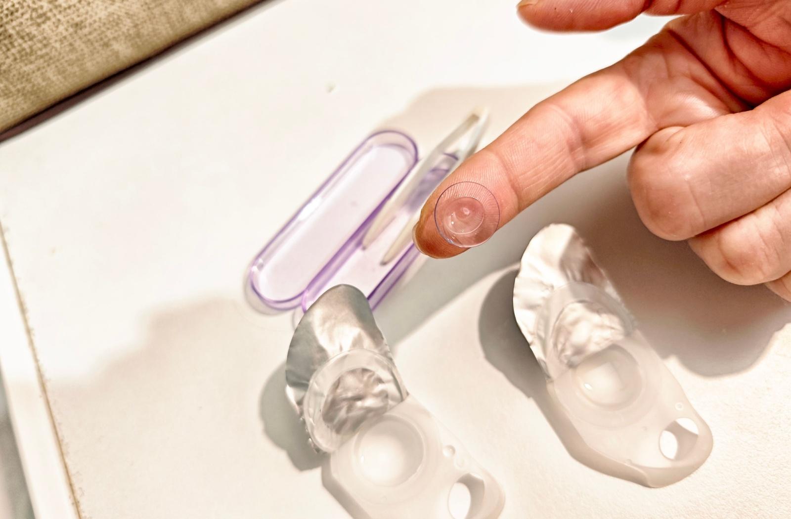 a contact lens on a persons finger from a birds eye view